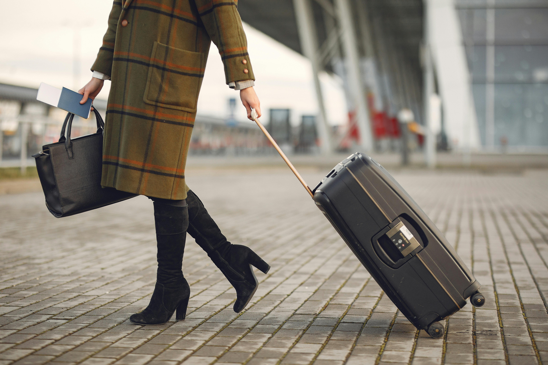 Confident woman traveler with luggage practicing safe travel habits